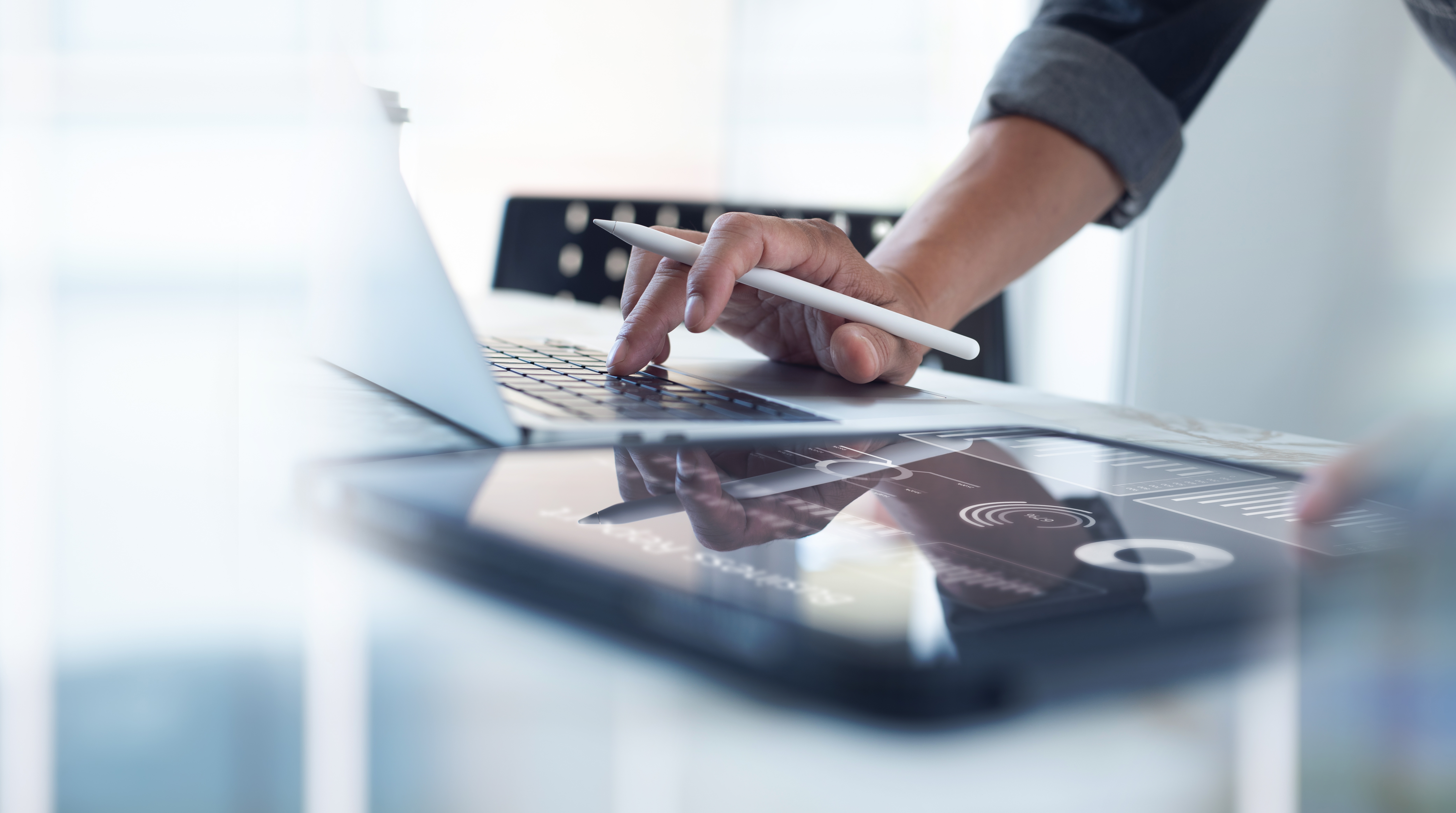 Businessman working on laptop, using mobile phone at modern office, analyzing business document with financial graph, market report on digital tablet, business data analysis concept